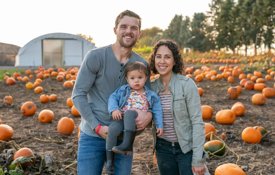 Adorable family at the pumpkin patch enjoying fall weather