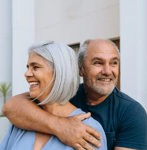 Older couple embracing and smiling.