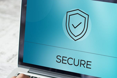 Closeup image of a person typing on a laptop with the word Secure and a shield icon with a checkmark in the middle on the screen