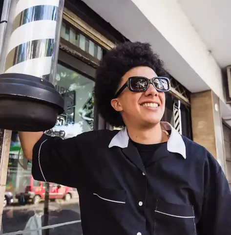 Young barber outside of his shop