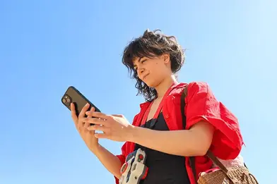 Woman making transfers using her mobile phone.