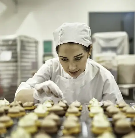 bakery owner inspecting cupcakes