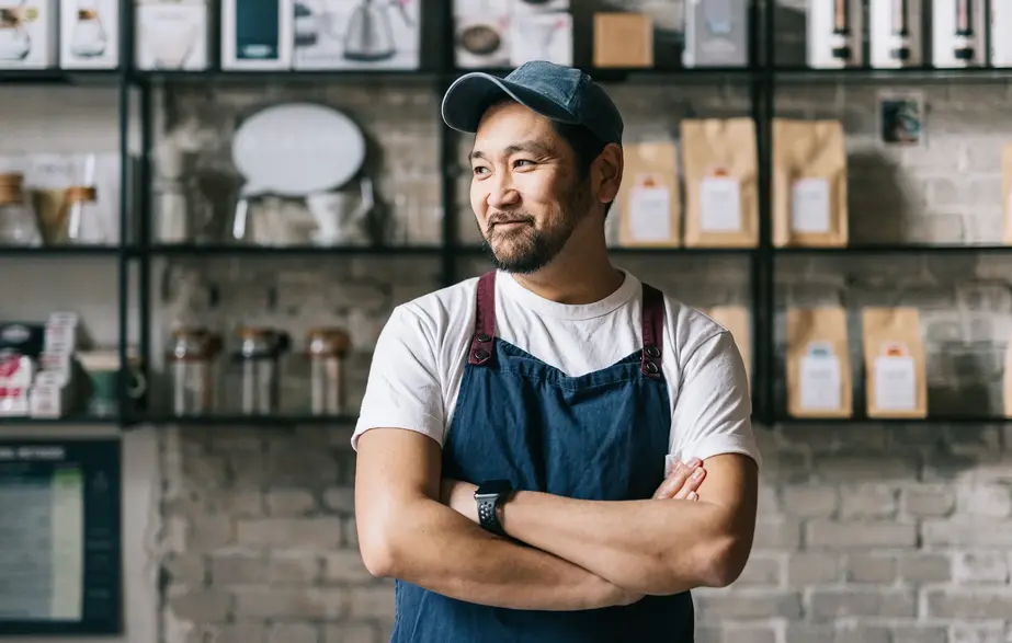 A man behind the counter of his coffee shop.