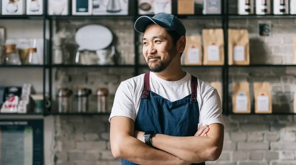 A man behind the counter of his coffee shop.