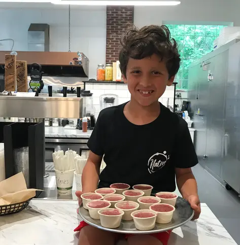 boy sitting on business counter with icecream