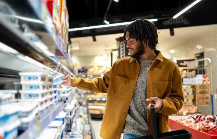 Man with shopping basket choosing groceries