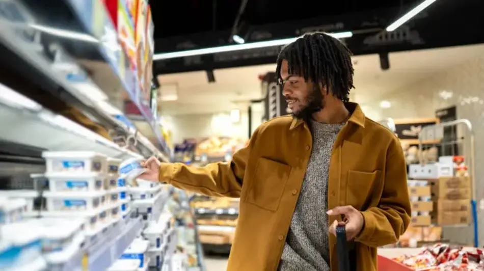 Man with shopping basket choosing groceries