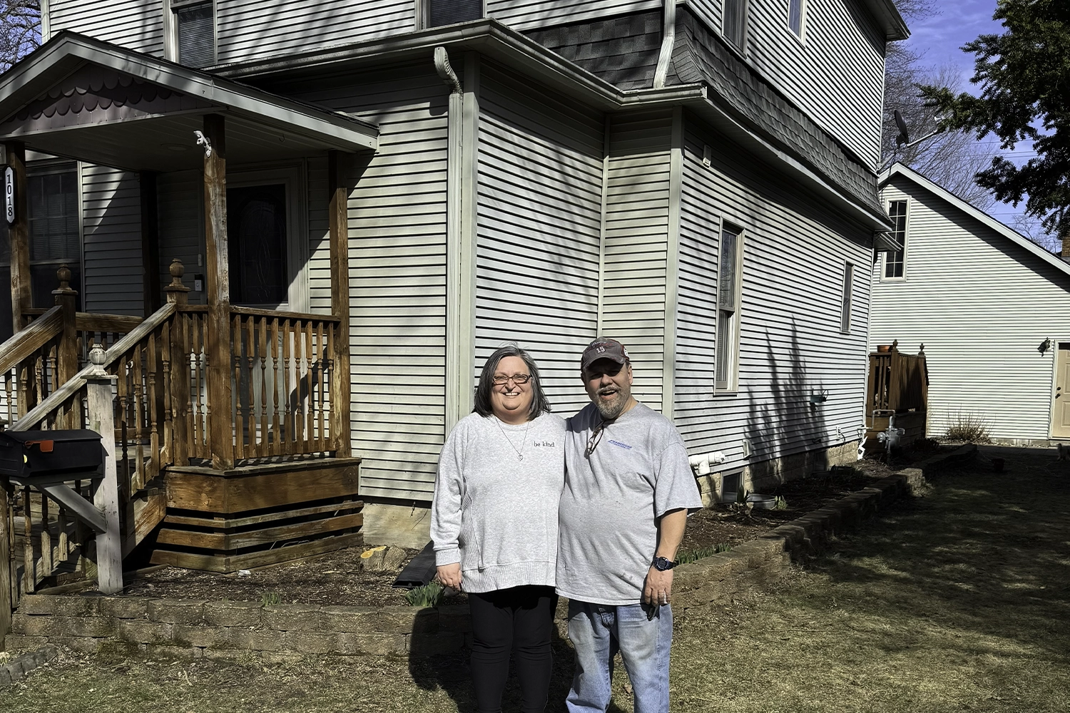 Member Adam posing in front of newly purchased home