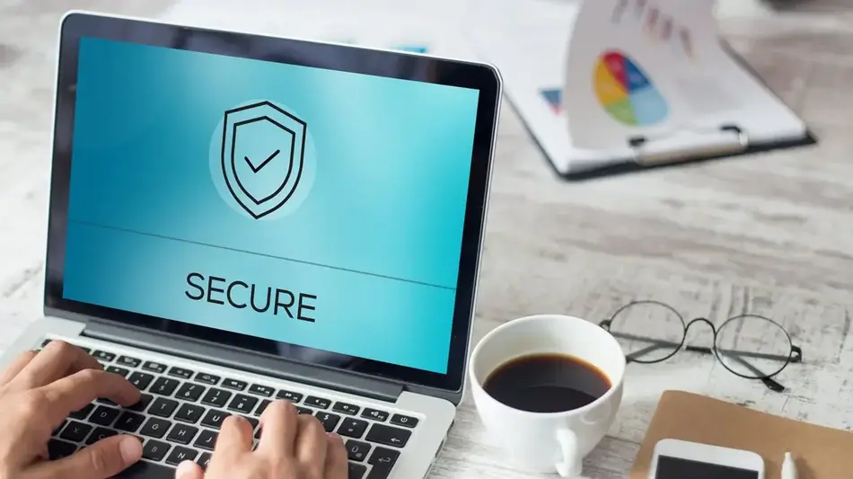 Image from a person's point of view while they type on a laptop computer, the word Security and a security icon showing on the screen