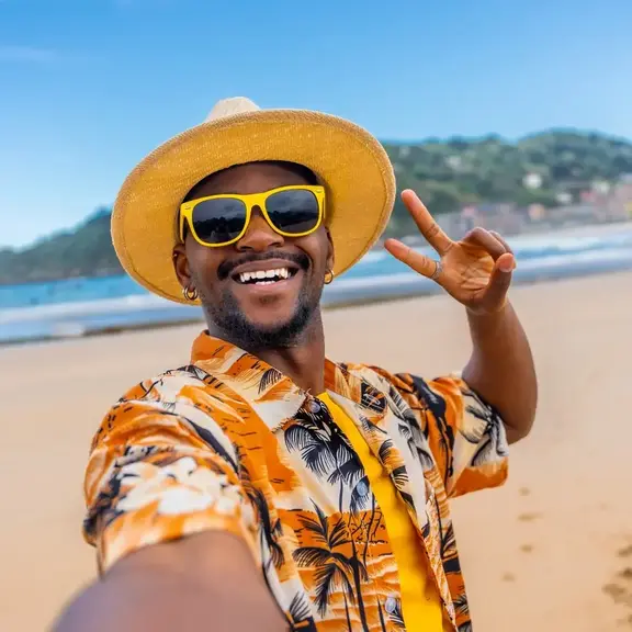 man enjoying sun on beach with peace sign image