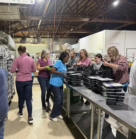 Everwise employees work to package free meals for children during the 2025 Day of Giving