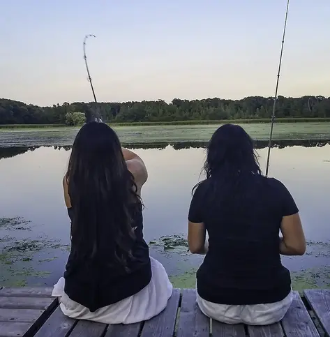 2 members fishing on a pier with fishing poles they bought with their certificate savings