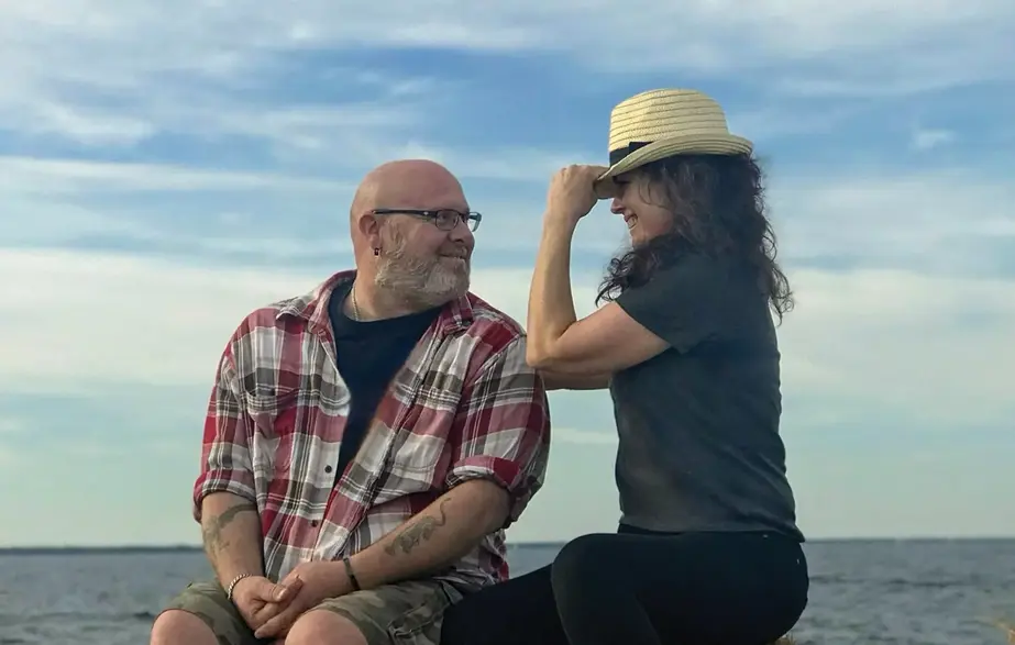 couple on the water flirting with hat