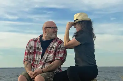 couple on the water flirting with hat