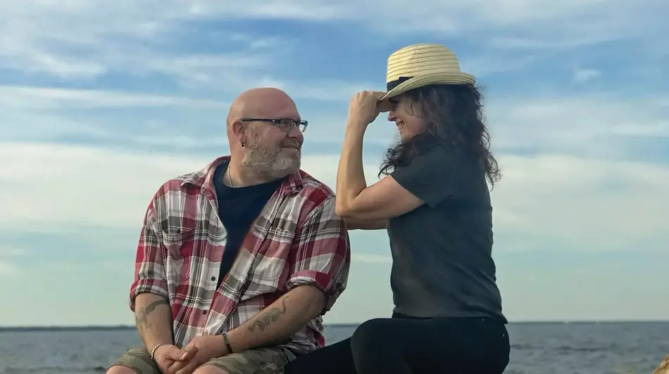 couple on the water flirting with hat