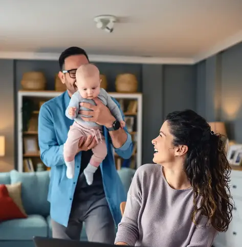 Family with a baby at home, mom using a laptop
